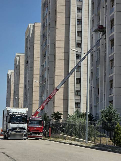 Apartman cephesine uzatılmış mobil asansör ve yanında Ulaşan Nakliyat kamyonu